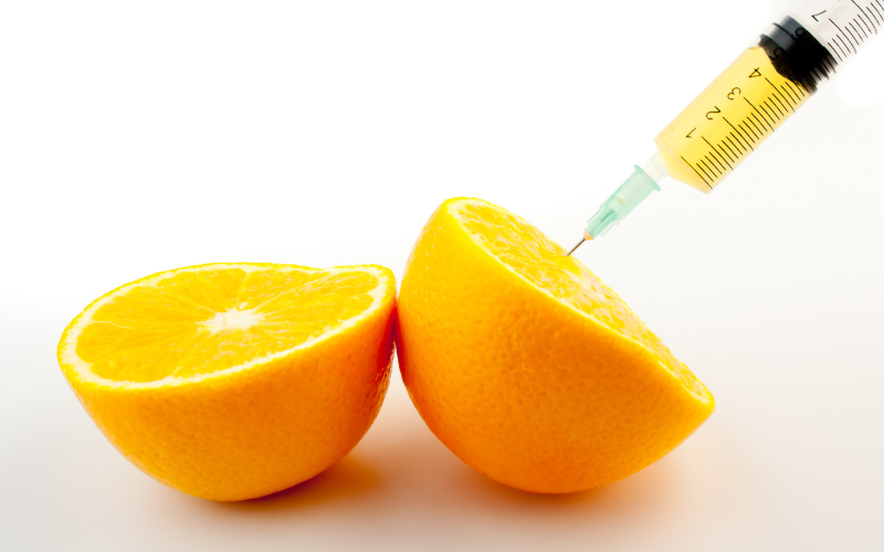 Syringe extracting vitamins from oranges